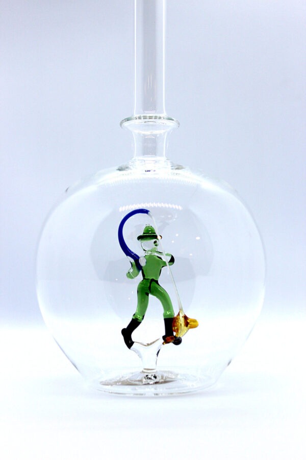 Eine leere bauchige Flasche aus Glas mit einem aus Glas geblasenen Angler im Inneren.