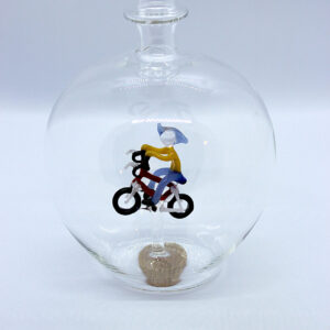 Motivflasche mit Fahrradfahrer 500 ml Eine leere bauchige Flasche aus Glas mit einem aus Glas geblasenen Radfahrer im Inneren.