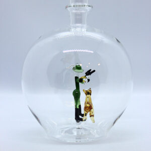 Eine leere bauchige Flasche aus Glas mit einem aus Glas geblasenen Jäger mit Hund im Inneren.