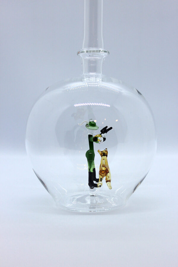 Eine leere bauchige Flasche aus Glas mit einem aus Glas geblasenen Jäger mit Hund im Inneren.