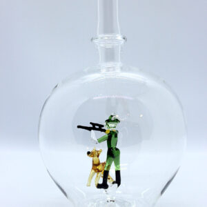 Eine leere bauchige Flasche aus Glas mit einem aus Glas geblasenen Jäger mit Hund im Inneren.