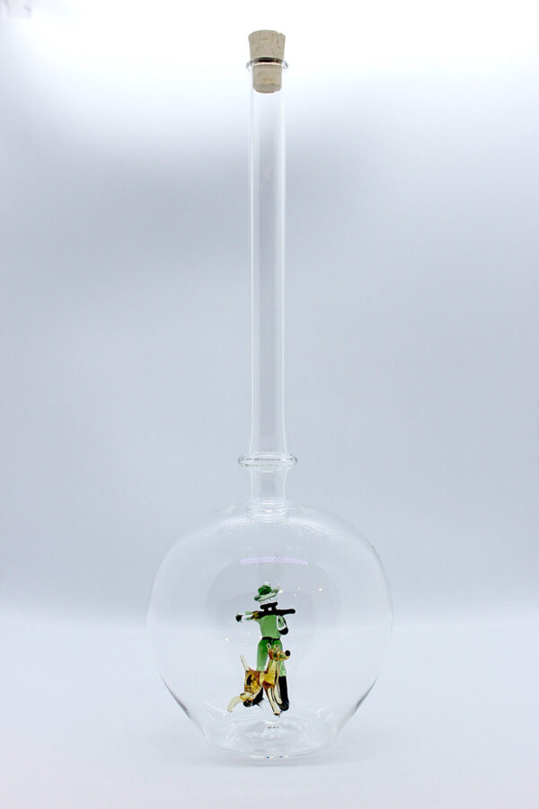 Eine leere bauchige Flasche aus Glas mit einem aus Glas geblasenen Jäger mit Hund im Inneren.