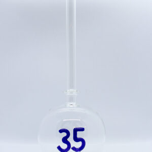 Eine leere bauchige Flasche aus Glas mit einer aus Glas geblasenen Zahl 35 im Inneren.