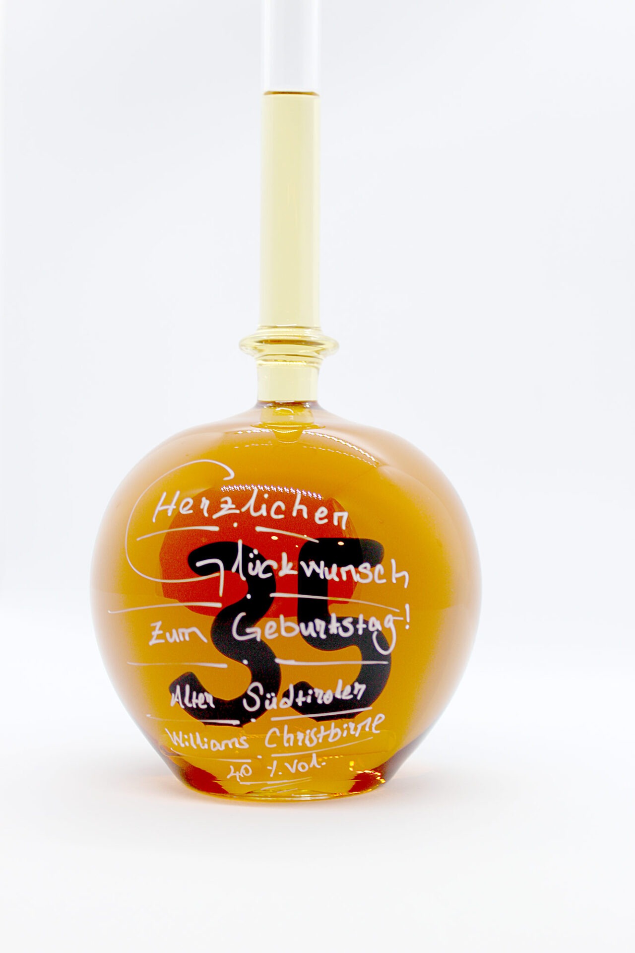 Eine mit Williams Christbirne befüllte bauchige Flasche aus Glas mit einer aus Glas geblasenen Zahl 35 im Inneren.