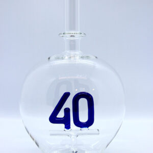 Eine leere bauchige Flasche aus Glas mit einer aus Glas geblasenen Zahl 40 im Inneren.