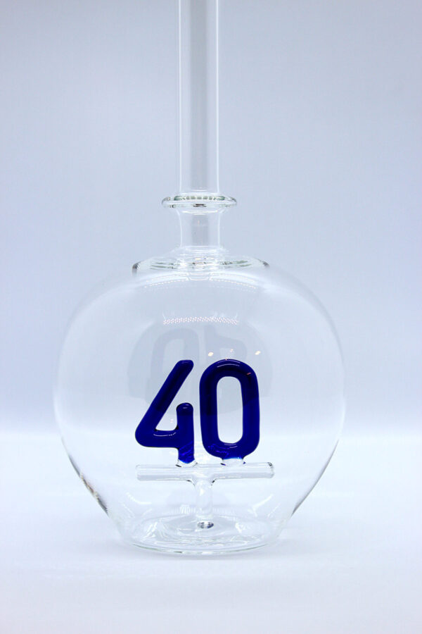 Eine leere bauchige Flasche aus Glas mit einer aus Glas geblasenen Zahl 40 im Inneren.