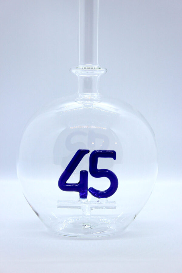 Eine leere bauchige Flasche aus Glas mit einer aus Glas geblasenen Zahl 40 im Inneren.