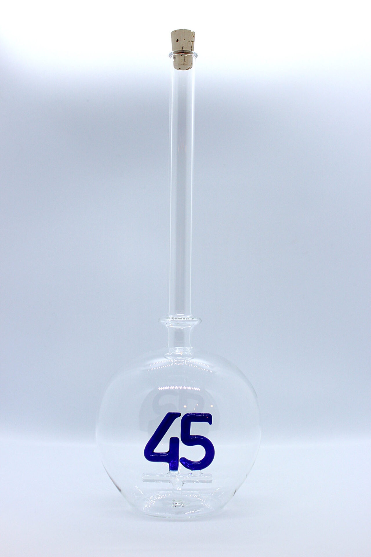 Eine leere bauchige Flasche aus Glas mit einer aus Glas geblasenen Zahl 40 im Inneren.