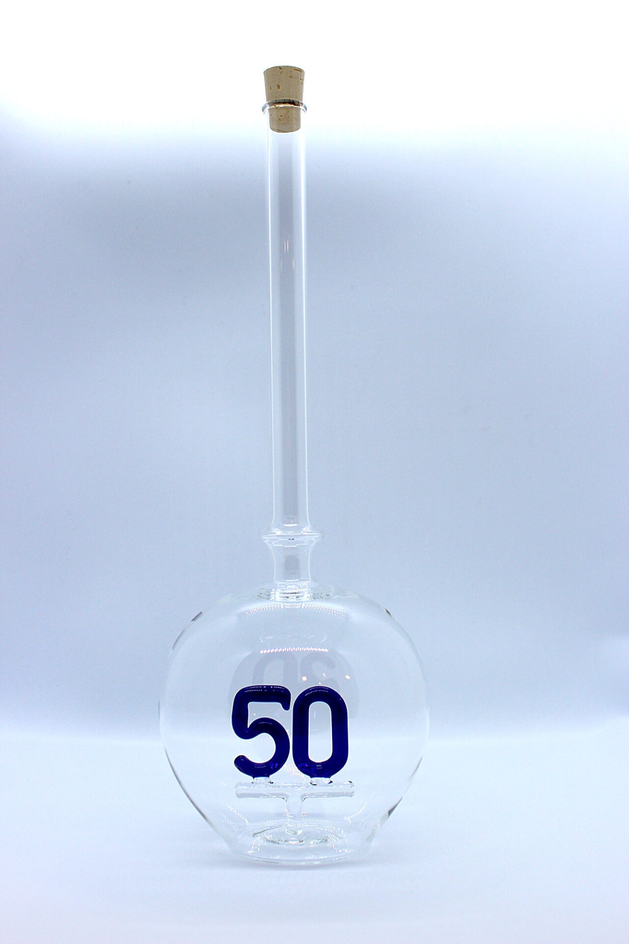 Eine leere bauchige Flasche aus Glas mit einer aus Glas geblasenen Zahl 50 im Inneren.