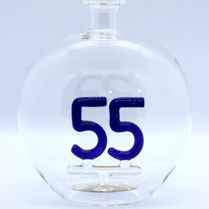 Eine leere bauchige Flasche aus Glas mit einer aus Glas geblasenen Zahl 55 im Inneren.