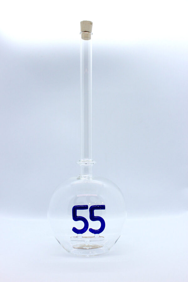 Eine leere bauchige Flasche aus Glas mit einer aus Glas geblasenen Zahl 55 im Inneren.