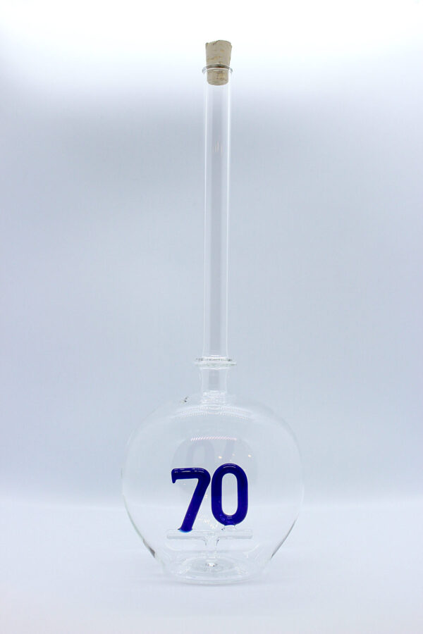 Eine leere bauchige Flasche aus Glas mit einer aus Glas geblasenen Zahl 70 im Inneren.