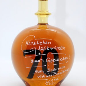 Eine mit Williams Christbirne befüllte bauchige Flasche aus Glas mit einer aus Glas geblasenen Zahl 70 im Inneren.