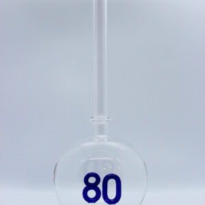 Eine leere bauchige Flasche aus Glas mit einer aus Glas geblasenen Zahl 80 im Inneren.