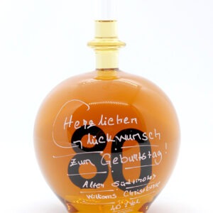 Eine mit Williams Christbirne befüllte bauchige Flasche aus Glas mit einer aus Glas geblasenen Zahl 80 im Inneren.