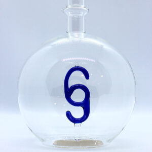 Motivflasche mit Paragraf 500 ml Eine leere bauchige Flasche aus Glas mit einem aus Glas geblasenen Paragraphen-Zeichen im Inneren.