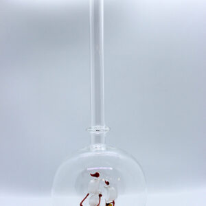 Eine leere bauchige Flasche aus Glas mit einem aus Glas geblasenen Segelschiff im Inneren.