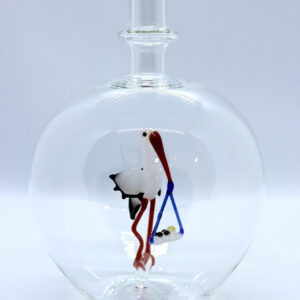 Eine leere bauchige Flasche aus Glas mit einem aus Glas geblasenen Storch mit Baby im Inneren.