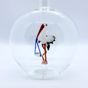 Eine leere bauchige Flasche aus Glas mit einem aus Glas geblasenen Storch mit Baby im Inneren.