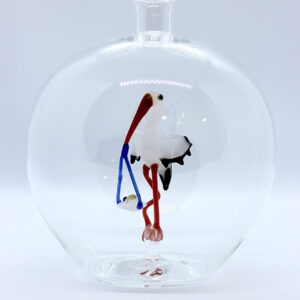 Eine leere bauchige Flasche aus Glas mit einem aus Glas geblasenen Storch mit Baby im Inneren.