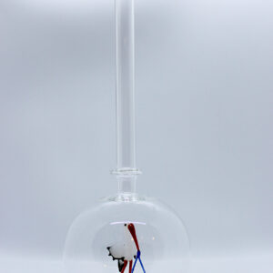 Eine leere bauchige Flasche aus Glas mit einem aus Glas geblasenen Storch mit Baby im Inneren.