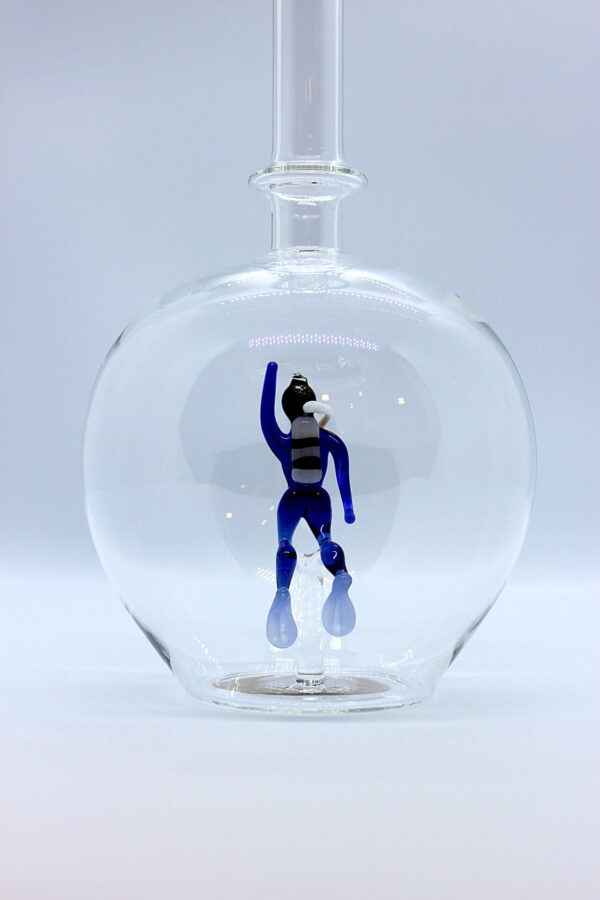 Eine leere bauchige Flasche aus Glas mit einem aus Glas geblasenen Taucher im Inneren.