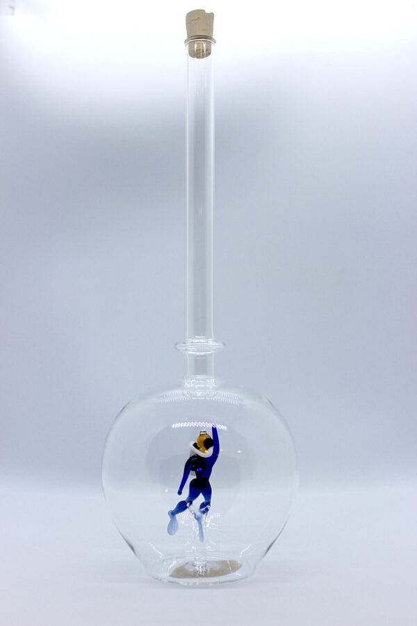 Eine leere bauchige Flasche aus Glas mit einem aus Glas geblasenen Taucher im Inneren.