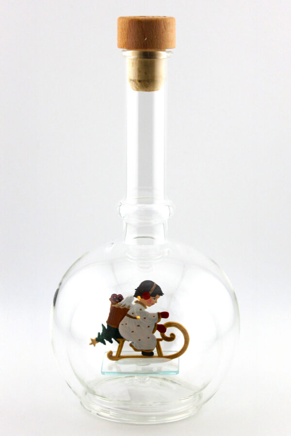 Eine leere bauchige Flasche aus Glas mit einem schlittenfahrenden Engel im Inneren.