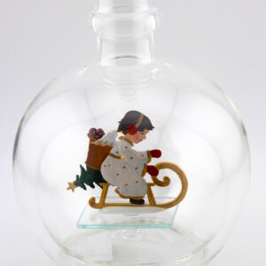 Eine leere bauchige Flasche aus Glas mit einem schlittenfahrenden Engel im Inneren.