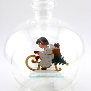 Eine leere bauchige Flasche aus Glas mit einem schlittenfahrenden Engel im Inneren.