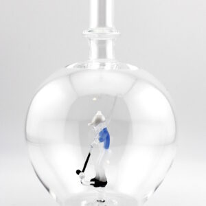 Eine leere bauchige Flasche aus Glas mit einem aus Glas geblasenen Golfspieler im Inneren.