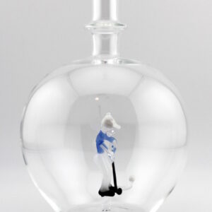 Eine leere bauchige Flasche aus Glas mit einem aus Glas geblasenen Golfspieler im Inneren.