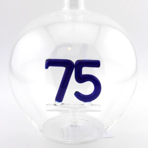 Eine leere bauchige Flasche aus Glas mit einer aus Glas geblasenen Zahl 75 im Inneren.