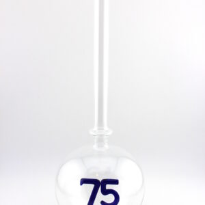 Eine leere bauchige Flasche aus Glas mit einer aus Glas geblasenen Zahl 75 im Inneren.