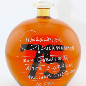 Eine mit Williams Christbirne befüllte bauchige Flasche aus Glas mit einer aus Glas geblasenen Zahl 75 im Inneren.