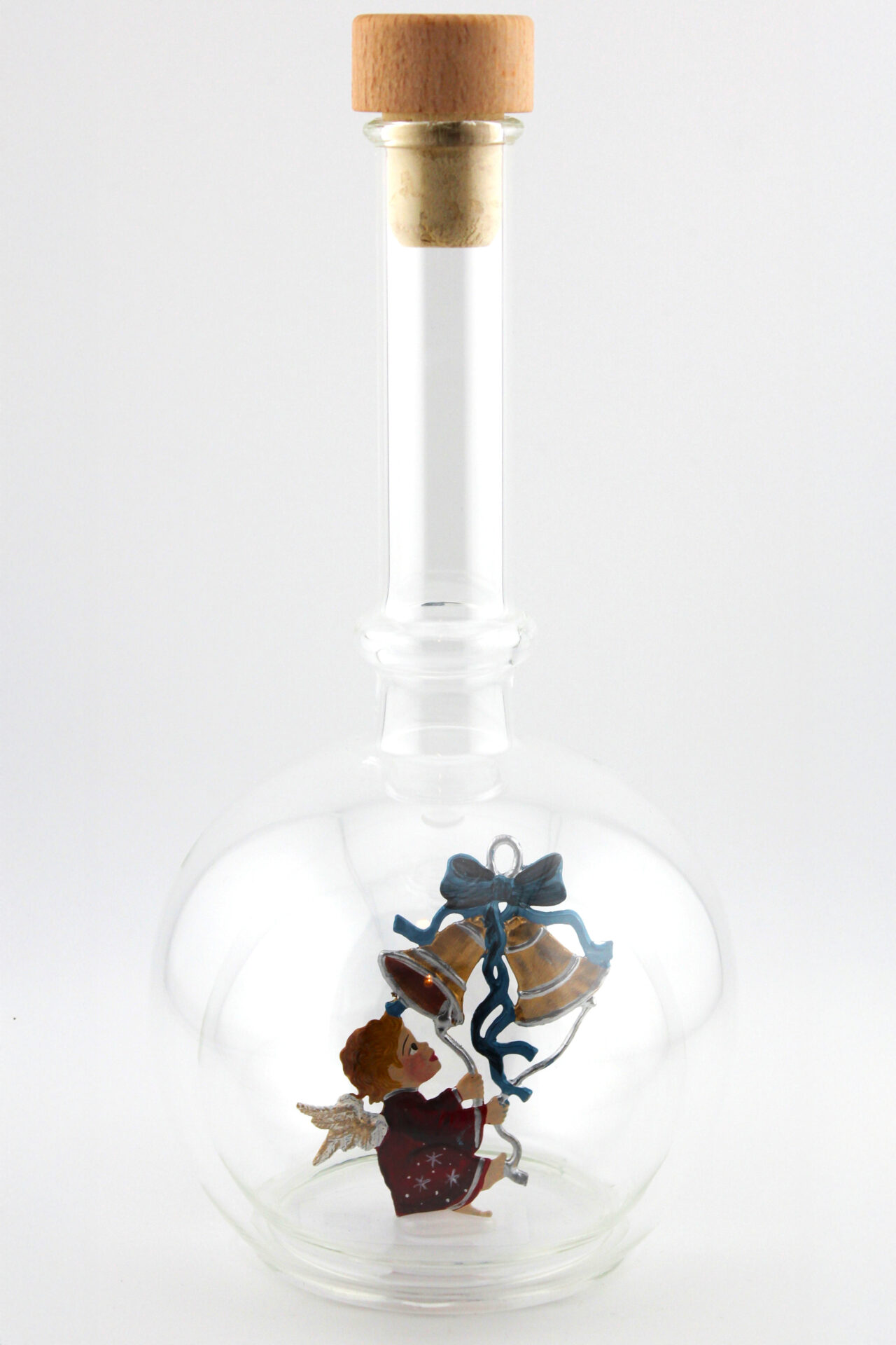 Eine leere bauchige Flasche aus Glas mit Weihnachtsläuten im Inneren.