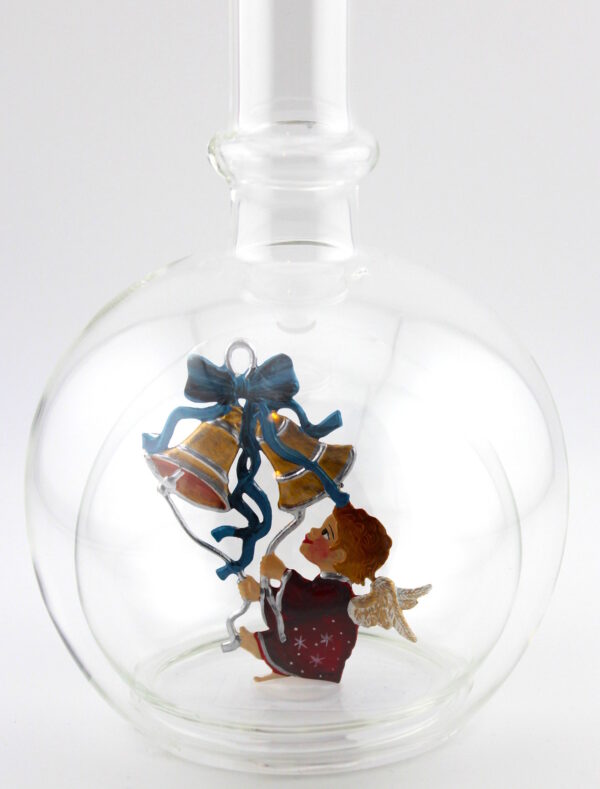 Eine leere bauchige Flasche aus Glas mit Weihnachtsläuten im Inneren.
