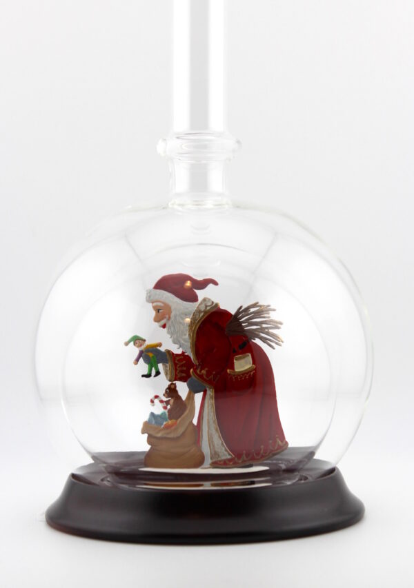Eine leere bauchige Flasche aus Glas mit Weihnachtsmann mit Geschenkesack im Inneren.