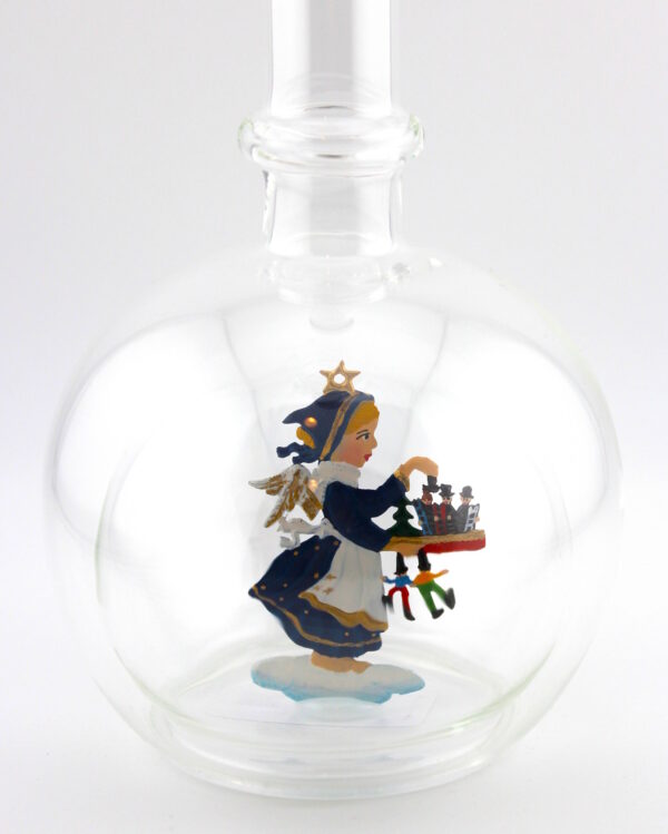 Eine leere bauchige Flasche aus Glas mit Weihnachtsmarkt Engel im Inneren.