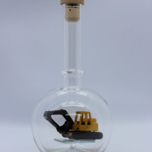 Eine leere bauchige Flasche aus Glas mit einem Bagger im Inneren.