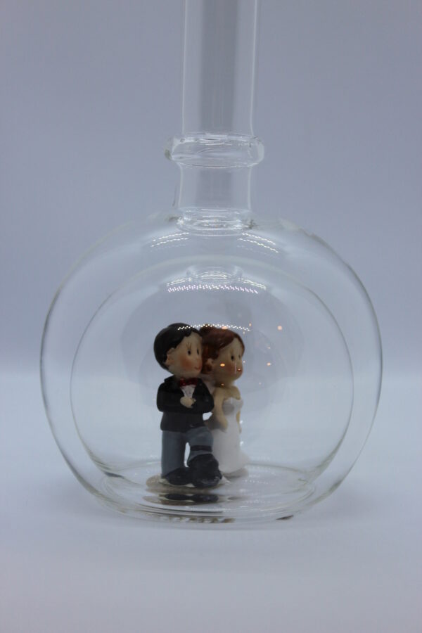 Eine leere bauchige Flasche aus Glas mit einem Brautpaar im Inneren.