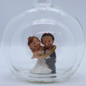 Eine leere bauchige Flasche aus Glas mit einem Brautpaar - gefangenem Bräutigam im Inneren.