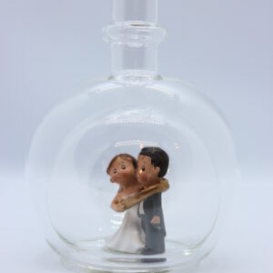 Eine leere bauchige Flasche aus Glas mit einem Brautpaar - gefangenem Bräutigam im Inneren.