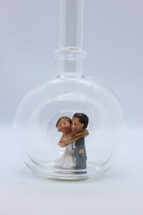 Eine leere bauchige Flasche aus Glas mit einem Brautpaar - gefangenem Bräutigam im Inneren.