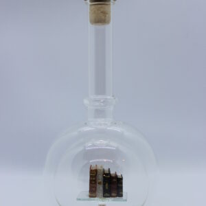 Eine leere bauchige Flasche aus Glas mit Büchern im Inneren.