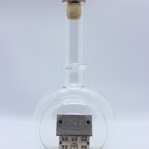Eine leere bauchige Flasche aus Glas mit einem Haus / Eigenheim im Inneren.