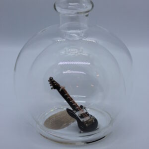 Eine leere bauchige Flasche aus Glas mit einer E-Gitarre im Inneren.