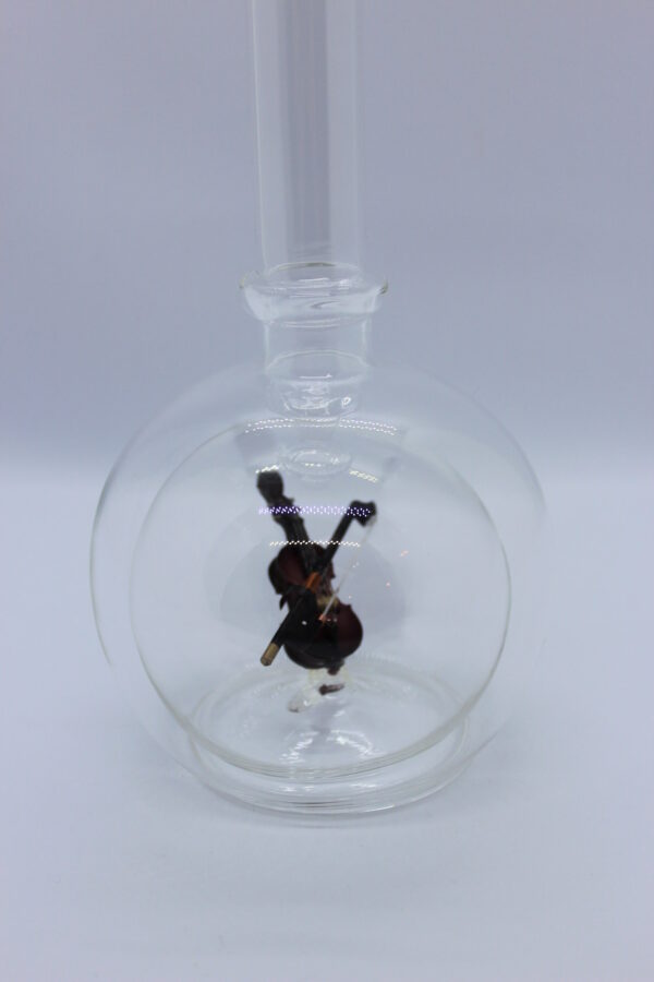 Eine leere bauchige Flasche aus Glas mit einer Geige im Inneren.