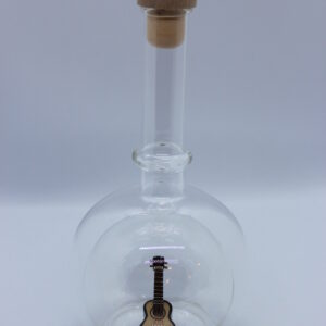 Eine leere bauchige Flasche aus Glas mit einer Gitarre im Inneren.