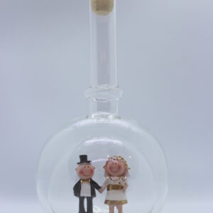 Eine leere bauchige Flasche aus Glas mit einem Goldenen Hochzeitspaar im Inneren.